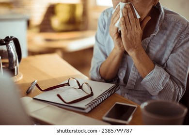 Close up senior woman sneezes into tissue - Powered by Shutterstock