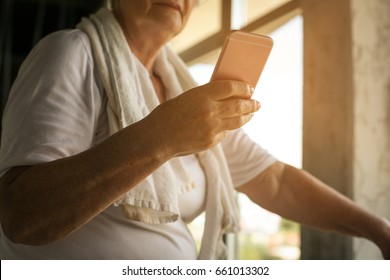 Close Up Of Senior Woman Typing Messages On Smart Phone. Workout In Gym.