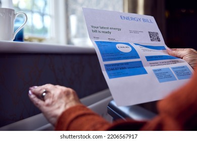 Close Up Of Senior Woman In Wheelchair With Energy Bill By Radiator In Cost Of Living Energy Crisis