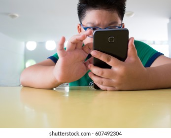 Close Up Serious Asian Boy Playing On Smart Phone