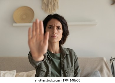 Close up serious confident strong woman showing stop gesture with hand, looking at camera, young female protesting against domestic violence and abuse, bullying, saying no to gender discrimination