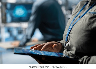 Close up of server farm IT expert using tablet to improve deep learning AI systems workloads. Data center software developer using device to adjust artificial intelligence model parameters
