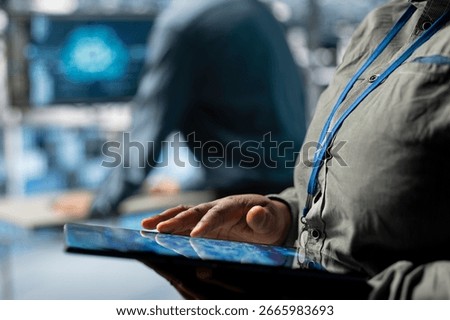 Close up of server farm IT expert using tablet to improve deep learning AI systems workloads. Data center software developer using device to adjust artificial intelligence model parameters