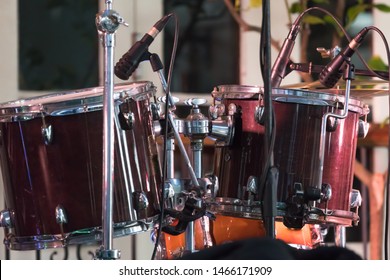 Close Up Of Set Of Drums Or Drum Kit Pair On Empty Stage With No-one Or Nobody And Microphones Set Up For Music Gig Or Concert