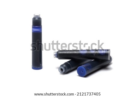 Close up of several blue plastic ink cartridges for fountain pens side by side and one above the other on white background