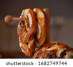 Close up several fresh traditional German pretzel bread knots hanging on retail display, low angle side view