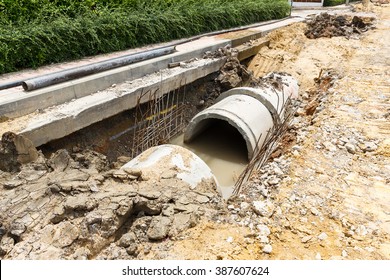 Close up sewer pipe installation beside footpath in city