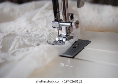 Close Up Of A Sewing Machine Making Alterations Of A Bride's Wedding Dress.