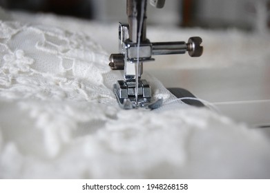 Close up of a sewing machine making alterations of a bride's wedding dress.