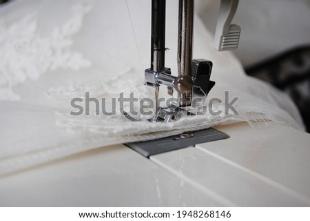 Close up of a sewing machine making alterations of a bride's wedding dress.