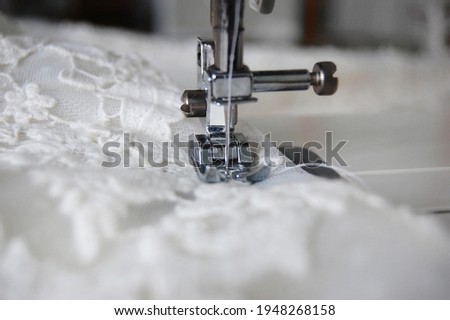 Close up of a sewing machine making alterations of a bride's wedding dress.