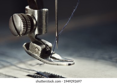 Close up of sewing machine needle with thread. Working part of antique sewing machine.