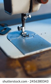 close up of sewing machine needle with thread. Working part of an antique sewing machine.