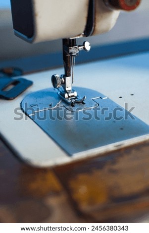 close up of sewing machine needle with thread. Working part of an antique sewing machine.