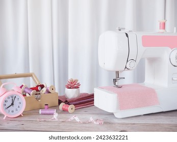 Close up sewing machine working with pink fabric, sewing accessories on the table, stitch new clothing. - Powered by Shutterstock