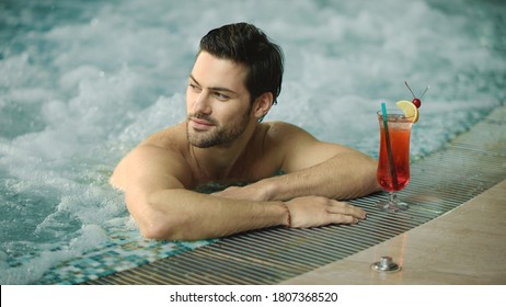 Close Up Of Sexy Man Flirting At Pool Indoor In Slow Motion. Portrait Of Handsome Guy Relaxing In Whirlpool Bath. Closeup Man Posing For Camera At Luxury Pool.