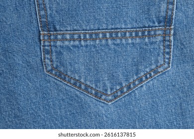 Close up of shape and stitching pattern on back pocket of blue jeans. Detailed denim seam design with visible thread and texture. Fashion concept for clothing detail, textile design, and apparel branding