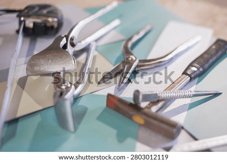 Close up of sheet metal working tools, tin snips hammer and tape measure