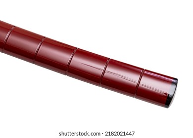 Close up shining crimson red 'Saya':  scabbard of a 'katana': Japanese long Sword with black horn tip. There are notch at the same distance. isolated in white background. selective focus.