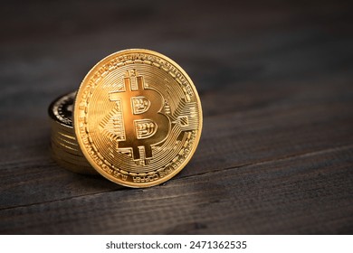 Close up of a shiny Bitcoin BTC Cryptocurrency Coin on a wooden background. Stock Market Concept.