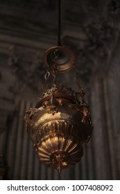 Close up to shiny and decorated copper lantern hanging inside a church