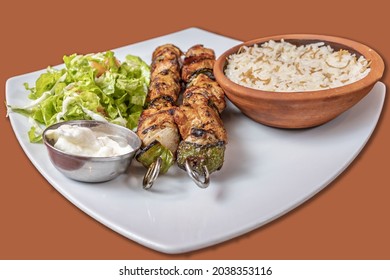 A Close Up Of Shish Taouk And White Sesame Paste And Rice In A Brown Little Bowl On A White Plate