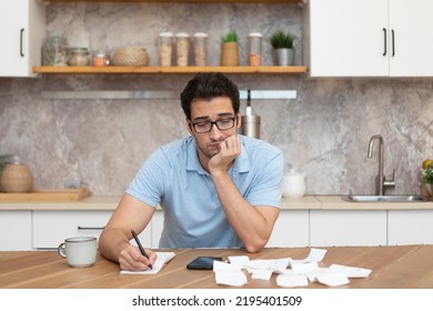 Close Up Of Shocked Man Sitting At The Table, Stressed And Confused By Calculate Expense From Invoice Or Bills, Have No Money To Pay Mortgage Or Loan. High Prices And Spending Money Concept