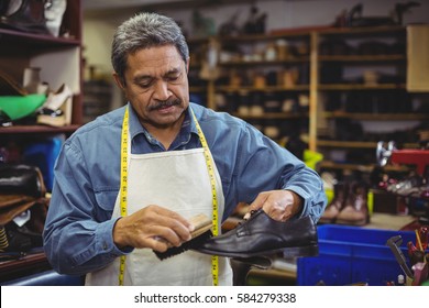 Close up of shoemaker polishing a shoe in workshop - Powered by Shutterstock