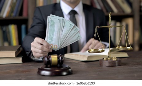 Close Up Shoot Of Judge Hand Holding Money In Court Room