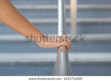 Close up shoot on a hand catching a stair rail. Woman aware about safety while walking on the stair way. Walking up or go down. Zdjęcia stock © 