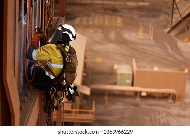 Close Up Shoot Of Rope Access Stick Welder Wearing Full Body Safety Harness Chin Straps Helmet Abseiling Working At Height Conducting Welding Chute Parent Repairs On Construction Site Perth, Australia