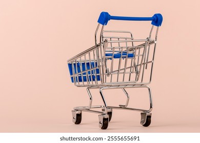 Close up of a shopping cart with a blue handle and a blue basket. Copy space. - Powered by Shutterstock