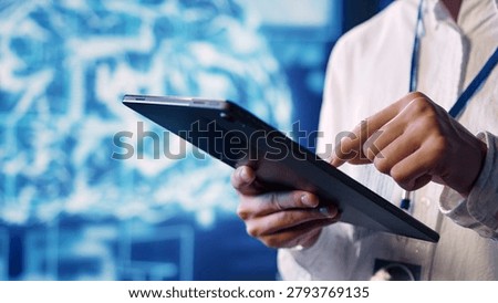 Close up shot of adept scientist in data center uses artificial intelligence computing simulating human brain thought processes, with skillful specialist works on tablet with AI machine learning.