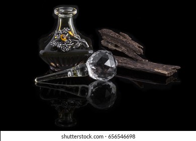 Close Up Shot OF Arabian Oud Oil Made Of Agar Wood In A Beautiful Glass Jar And Agar Wood Stick Isolated On Black Background
