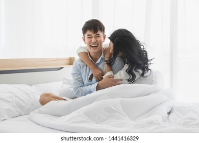 Close Up Shot Of Asian Couple On Bed Together, They Smile And Hug Each Other With Love.