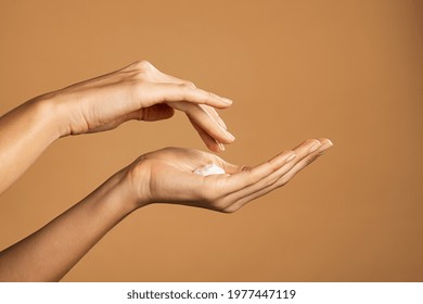 Close Up Shot Of Beautiful Female Hands Holding And Applying Moisturiser. Beauty Woman Hand Applying Cream. Beautiful Girl On Creamy Background Holding Moisturizer.