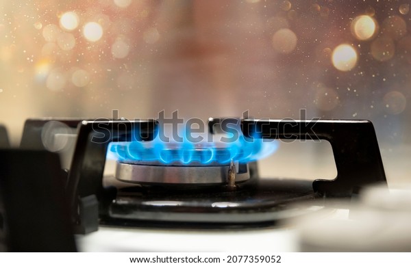 Close up shot of blue\
fire from domestic kitchen stove top. Gas cooker with burning\
flames of propane gas. Gas supply chain and news. Global gas crisis\
and price rise.