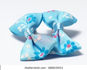 Close Up Shot Of Blue Tied Ribbon Hair Pin On A White Isolated Background