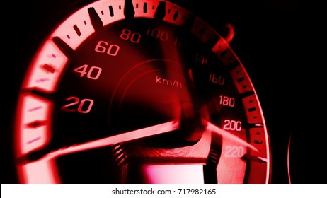 Close up shot and blurred mile indicatorof a speed meter in a car with red light speed at 220 Km/H in concept racing car
