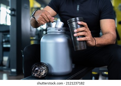 Close Up Shot Of Bodybuilder Hands Taking Protein Powder And Mixing With Water On Bottle By Shaking At Gym - Concpet Of Muscular Gain, Nutritional Supplement And Wellness.