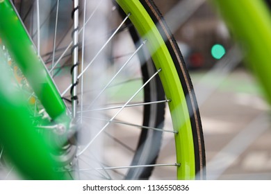 A Close Up Shot Of A Bright Green Bicycle Tire With The Busy Seattle Washington Streets In The Background. 