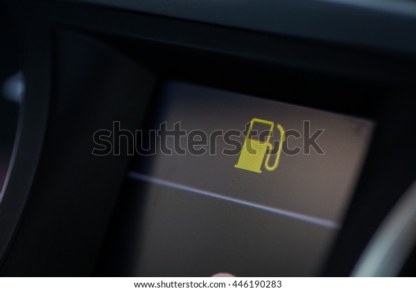 Close up shot of a car\'s dashboard with the fuel\
icon lit.