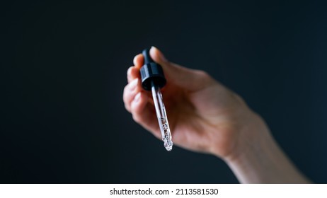 Close Up Shot Of Caucasian Hand Holding An Eye Dropper. Beauty Skincare.