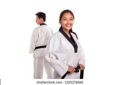 Close up shot of a cheerful female fighter wearing white traditional Gi, smiling at camera, her male partner standing on the background. Martial art concept portrait - Powered by Shutterstock