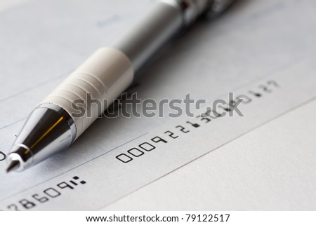 Close up shot of a cheque or cheque with a pen