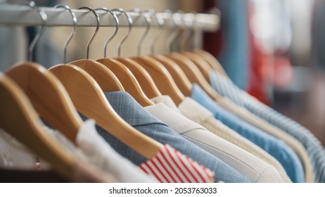 Close Up Shot Of Clothing Rack With Colorful Stylish Items. Shopping Center Interior. Modern Fashionable Shop, Clothes For Every Taste. Fashionable Design, Quality Sustainable Materials. No People.