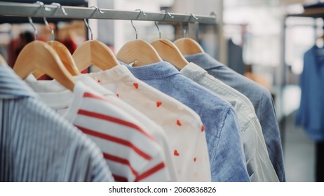 Close Up Shot Of Clothing Rack With Colorful Stylish Items. Shopping Center Interior. Modern Fashionable Shop, Clothes For Every Taste. Fashionable Design, Quality Sustainable Materials. No People.