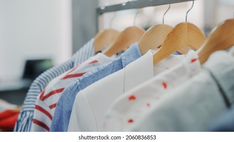 Close Up Shot Of Clothing Rack With Colorful Stylish Items. Shopping Center Interior. Modern Fashionable Shop, Clothes For Every Taste. Fashionable Design, Quality Sustainable Materials. No People.