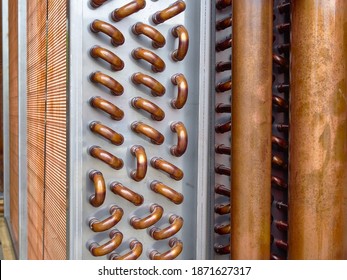 Close shot of copper plain tubes of a condenser coil.