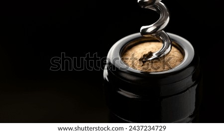 Close up shot of a corkscrew in the process of uncorking a bottle of wine, capturing the anticipation and celebration as the cork is about to be released.